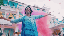 a man with his arms outstretched stands in front of a building