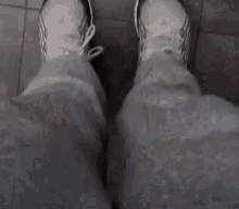 a person 's feet are visible in a blurry photo while standing on a concrete floor .