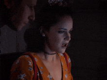 a woman with a choker looks at a man with the words oh mama behind her