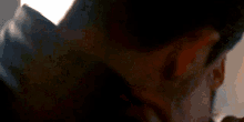 a close up of a person covering their ear with their hand .