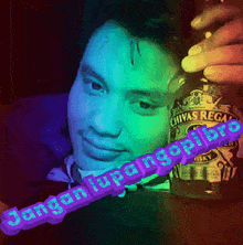 a man is holding a bottle of chivas regal