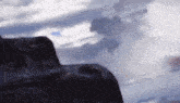 a painting of a mountain with a cloudy sky in the background