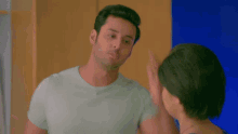 a woman in a blue shirt is talking to a man