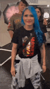 a woman with blue hair is wearing a black t-shirt that says maquette