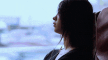 a woman looking out a window with her head resting on her arm