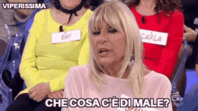 a woman is sitting in front of a group of women and says che cosa c ' e di male .