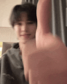 a blurry photo of a person giving a thumbs up sign