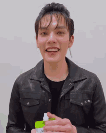 a man wearing a black leather jacket is smiling and holding a bag that says jelly on it
