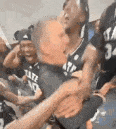 a group of basketball players are sitting in a locker room .