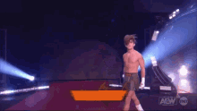 a man without a shirt is walking on a red carpet in front of a sign that says aew