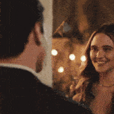 a man and woman are looking at each other and the woman is smiling
