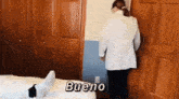 a woman in a lab coat is standing next to a bed .