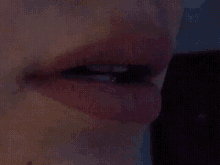 a close up of a woman 's mouth with a purple lipstick on it .