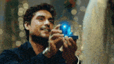 a man holding a blue box with a light inside