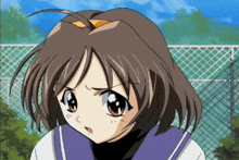 a girl with brown hair is standing in front of a fence and looking at the camera