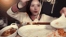 a woman is sitting at a table with plates of food
