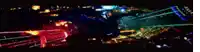 a blurry picture of a city at night with a blue light in the center