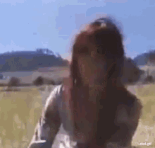 a blurry picture of a woman standing in a field with the text rbd.gif below her
