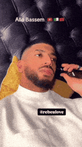a man with a beard is getting his hair shaved by someone named allo bassem