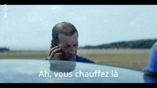 a man is talking on a cell phone and the words ah vous chauffez la are below him