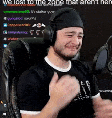a man wearing headphones is sitting in front of a microphone .