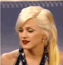 a close up of a woman 's face with blonde hair and red lipstick
