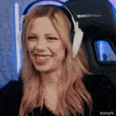 a woman wearing a pair of ewskill headphones is smiling