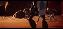 a group of robotic soldiers are running on a red surface