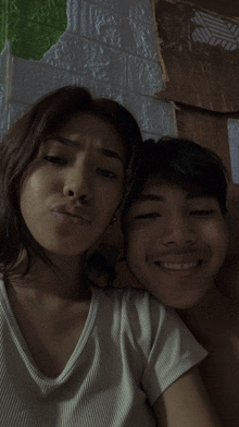 a man and a woman are posing for a picture and the woman is making a funny face