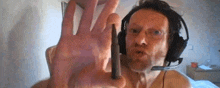 a man is wearing headphones and holding a bullet in his hand .