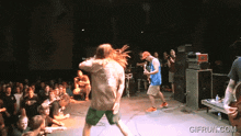 a crowd of people watching a band on stage with gifrun.com in the lower right corner