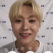 a young man wearing headphones and a white shirt is smiling .