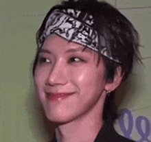 a close up of a person wearing a bandana on their head and smiling .