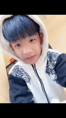 a boy with blue hair is wearing a white hoodie