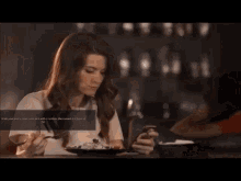 a man and woman sit at a table in a restaurant with a sign that says " front of "