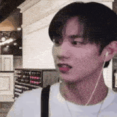 a young man wearing headphones is standing in front of a wall .