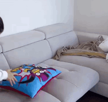 a person is putting a pillow on a couch that has a cartoon character on it