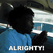 a man in a car says " alrighty " while looking out the window