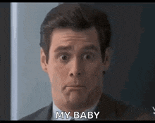 a man in a suit and tie is making a face and says `` my baby '' .