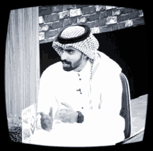 a black and white photo of a man wearing a turban and a watch