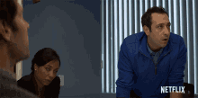 a man in a blue jacket with netflix written on the bottom right