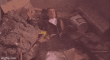 a person is laying in a pile of garbage with the words i lived above them .