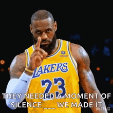 lebron james is wearing a lakers jersey and pointing his finger at the camera .