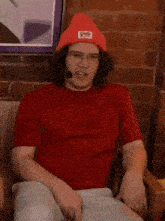 a man wearing a red shirt and a red beanie with the word gigg written on it