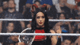 a woman in a demon costume holds a wrestling championship belt