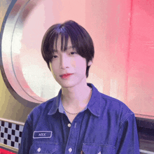 a young man wearing a denim shirt with the name nex on the front