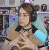 a woman wearing glasses and headphones making a heart shape with her hands