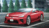 a red sports car is parked in a parking lot with a building in the background .