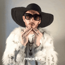 a man wearing a fur coat and a hat has the word mcdh on the bottom