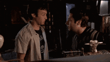 two men standing next to each other with one wearing a shirt that says ' axis ' on it